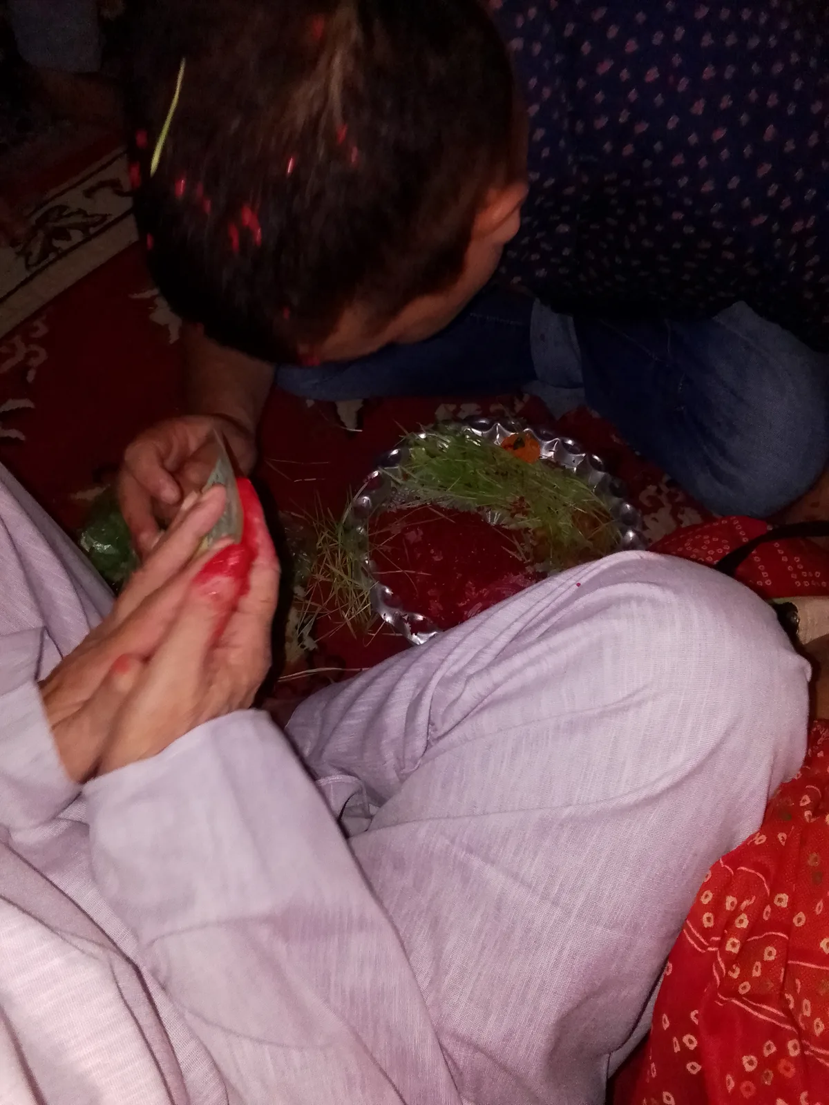Elder placing red Tika and Jamara blessing in Nepal