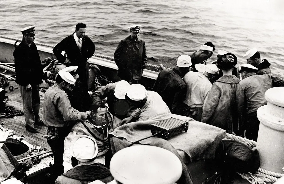 US Navy 030808-N-0000X-002 Cdr. Charles 'Swede' Momsen stands next to the rail (third from left) as USS Falcon (ASR 2) crewmen suit-up two Deep Sea Divers